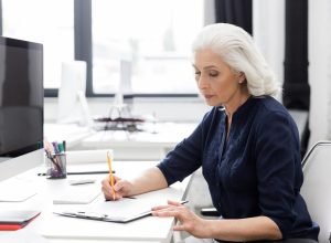 mature-business-woman-making-notes-piece-paper.jpg